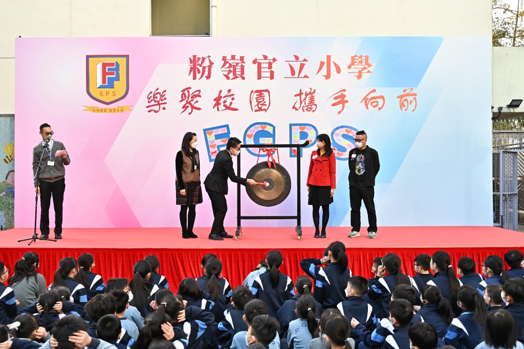图示施俊辉（左三）敲打铜锣，象征学校和学生的新开始