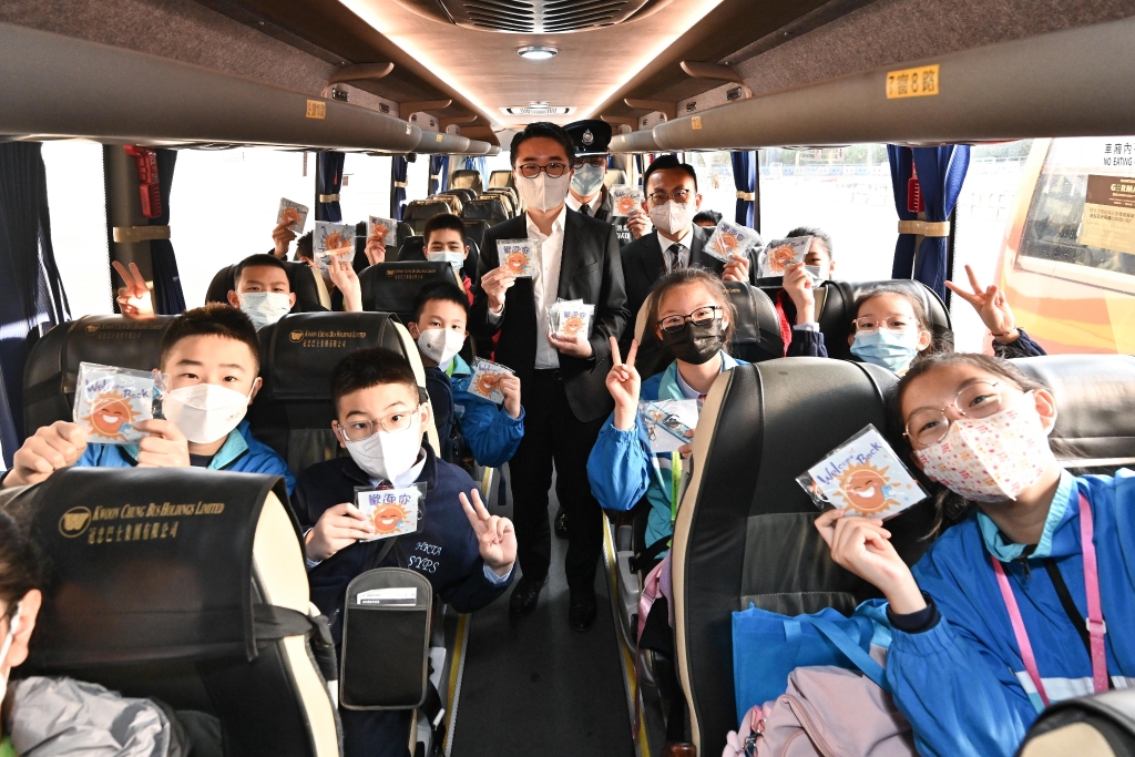 图示施俊辉（中）在校巴上与跨境学生合照