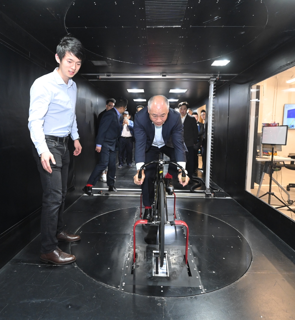 李寧博士（中）於風洞中試踩由科大研究團隊開發的單車空氣動力試驗台