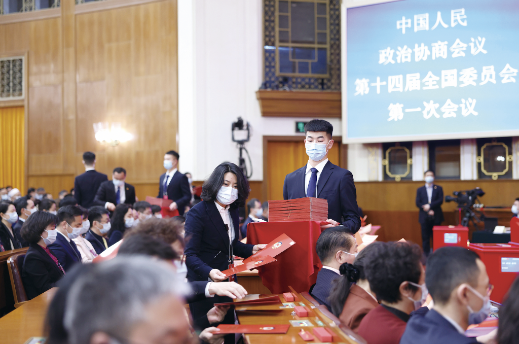 3月10日，全國政協十四屆一次會議在北京人民大會堂舉行第三次全體會議。這是工作人員發放選票（圖：新華社）