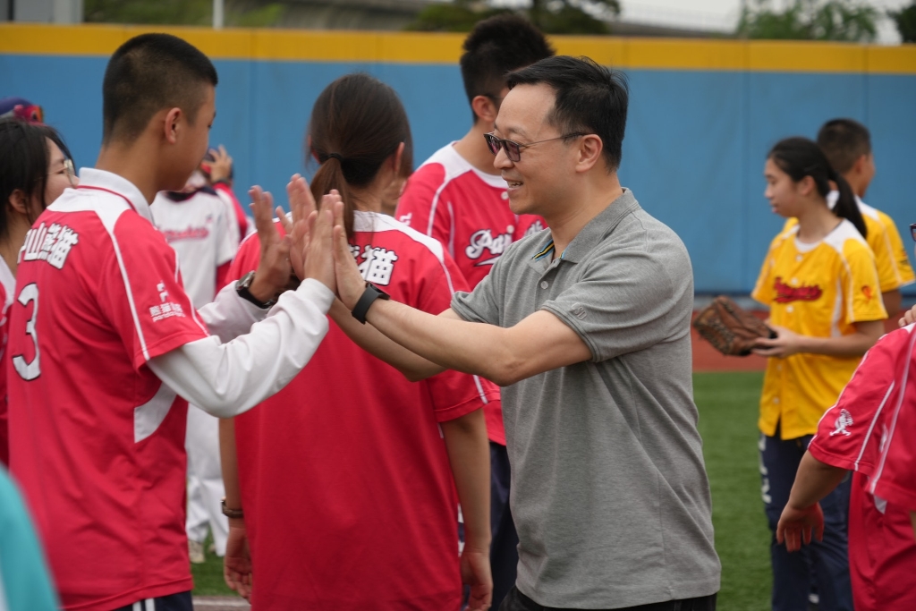香港與中山兩地學生進行棒球友誼賽，懲教署署長黃國興（前右）親身出席支持，並為團員打氣
